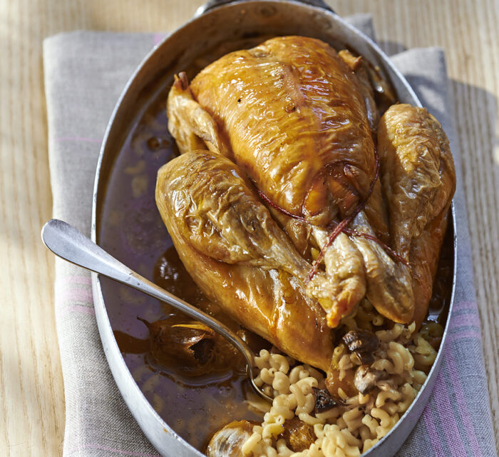 Poulet rôt servi dans un plat en acier avec des coquillettes croquantes et tendres