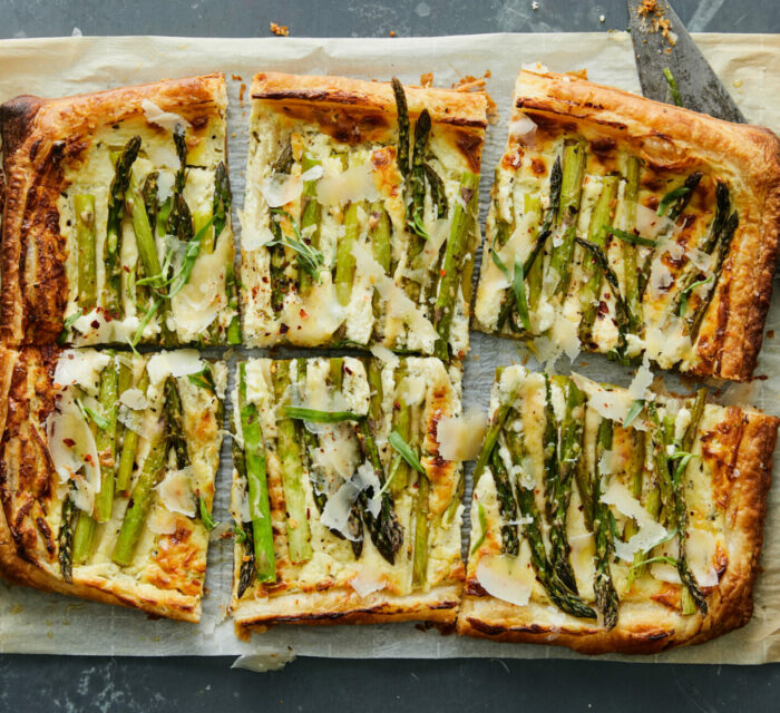 Tarte aux asperges, chèvre et parmesan coupé sur du papier allant au four