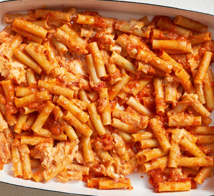 pâtes ziti avec de la sauce tomate, de la viande et du fromage dans un plat blanc allant au four