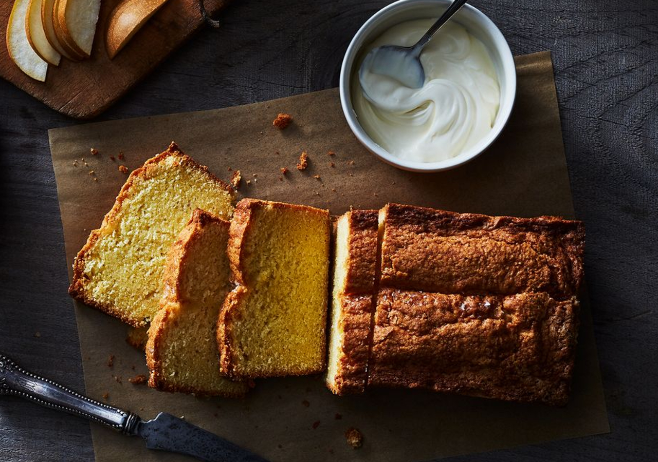 cake découpé sur une planche en bois avec un pot de yaourt à côté