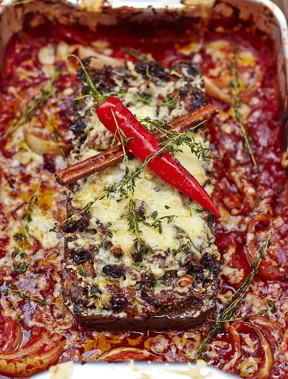 roti de noix dans une sauce rouge avec un piment rouge, de la cannelle et du fromage fondu