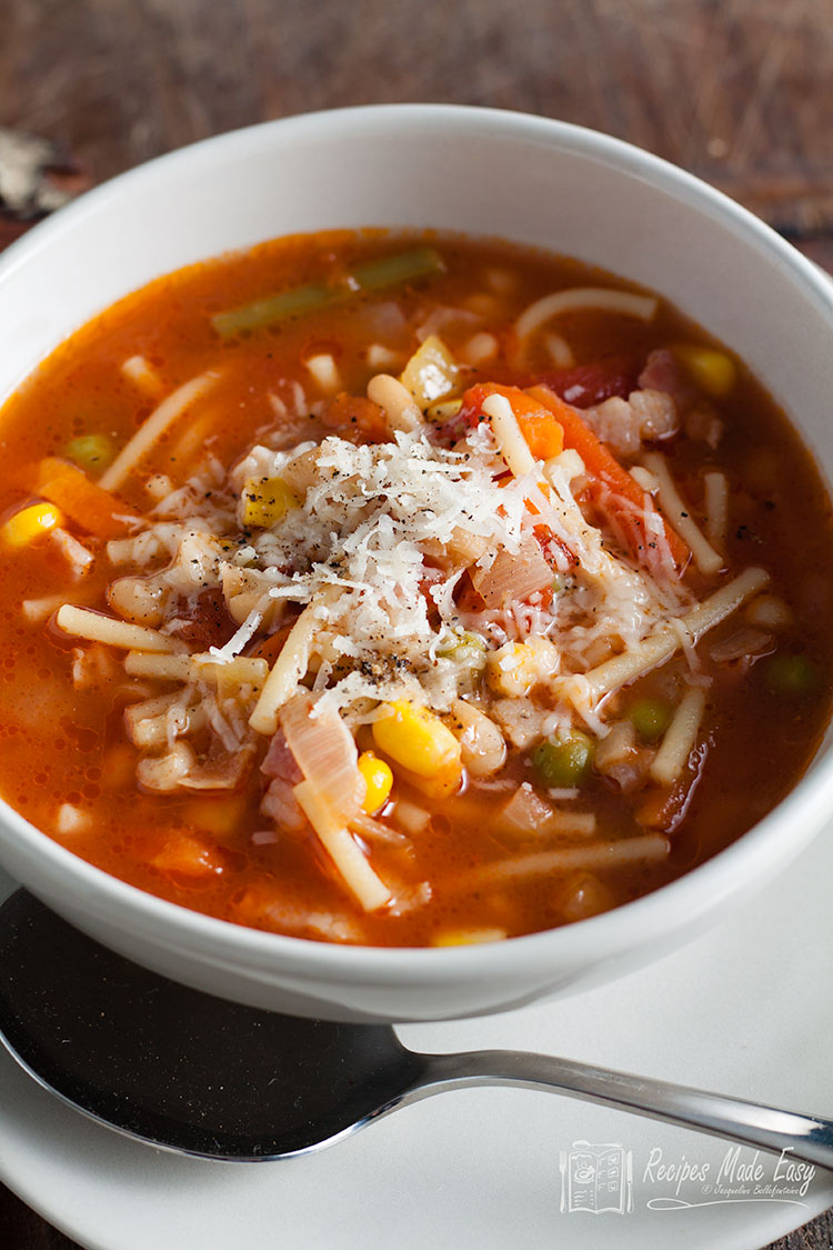 soupe de légumes avec un bouillon et des pâtes dans un bol blanc