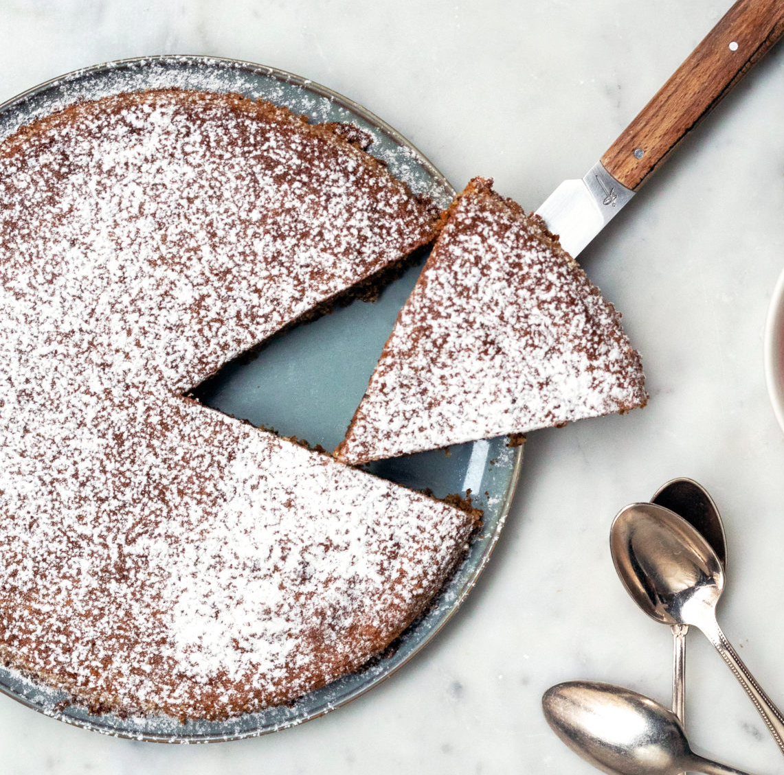 gâteau à la noisette avec du sucre glace par dessus et des cuillères