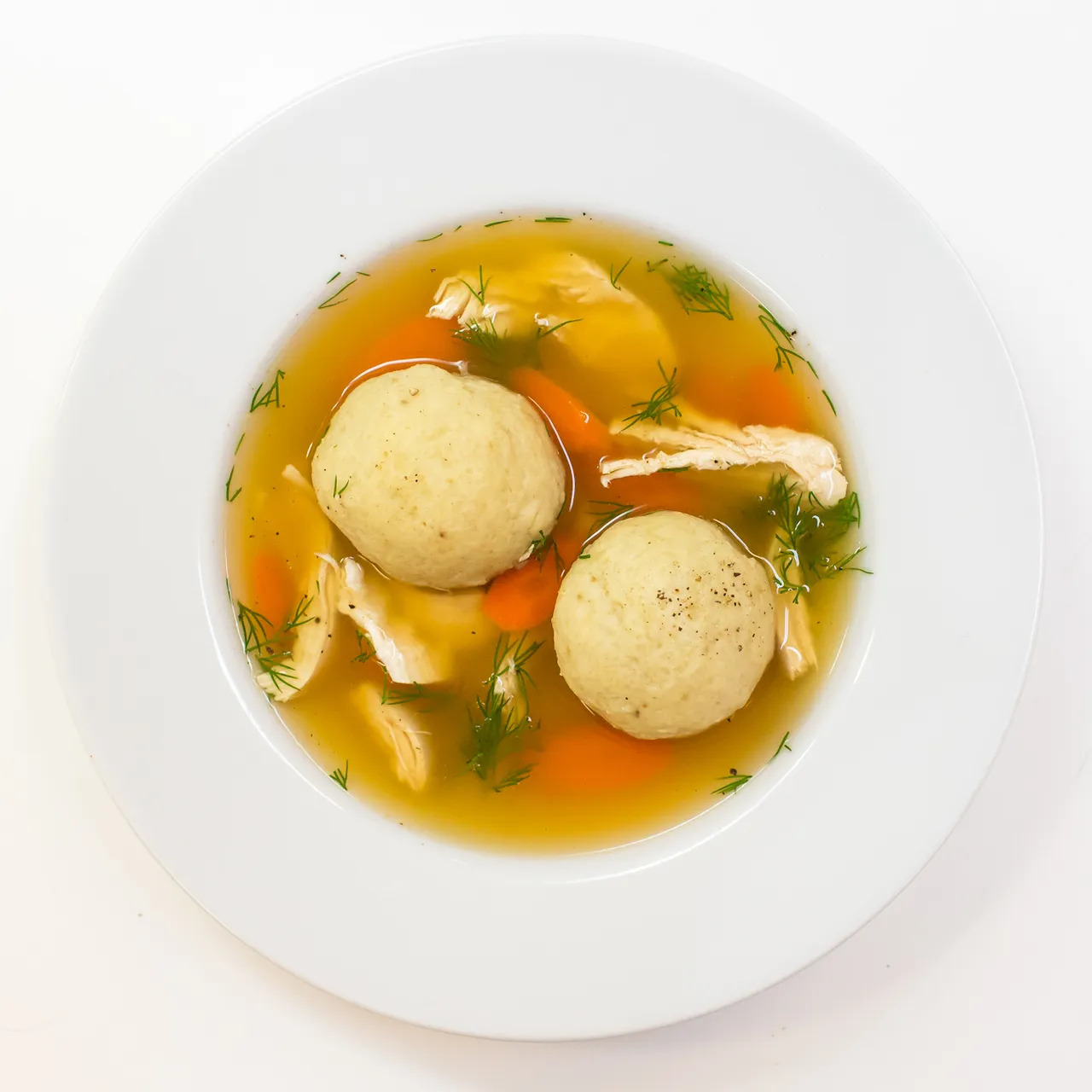 soup de boulettes avec des légumes dans une assiette creuse blanche