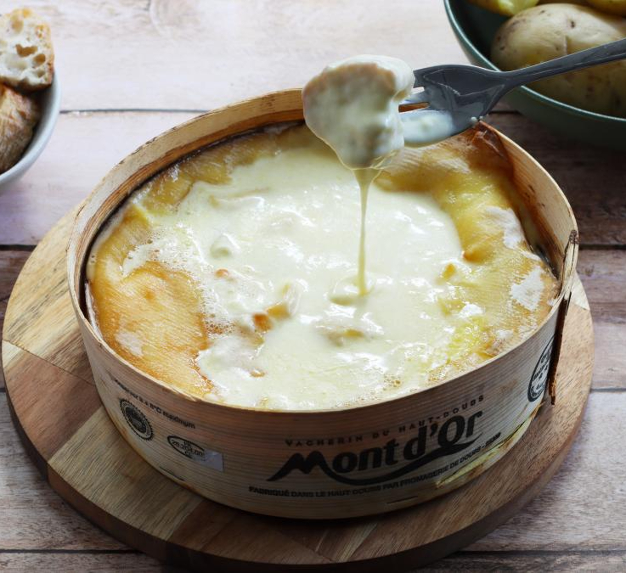 mont d'or aux saucisses avec une fourchette qui trempe du pain