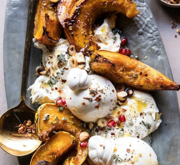 Courges et burrata cuits au four avec du buerre et du miel, servi dans un plat gris avec de la grenade