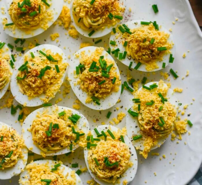 Oeufs Mimosa sur une assiette blanche avec des herbes