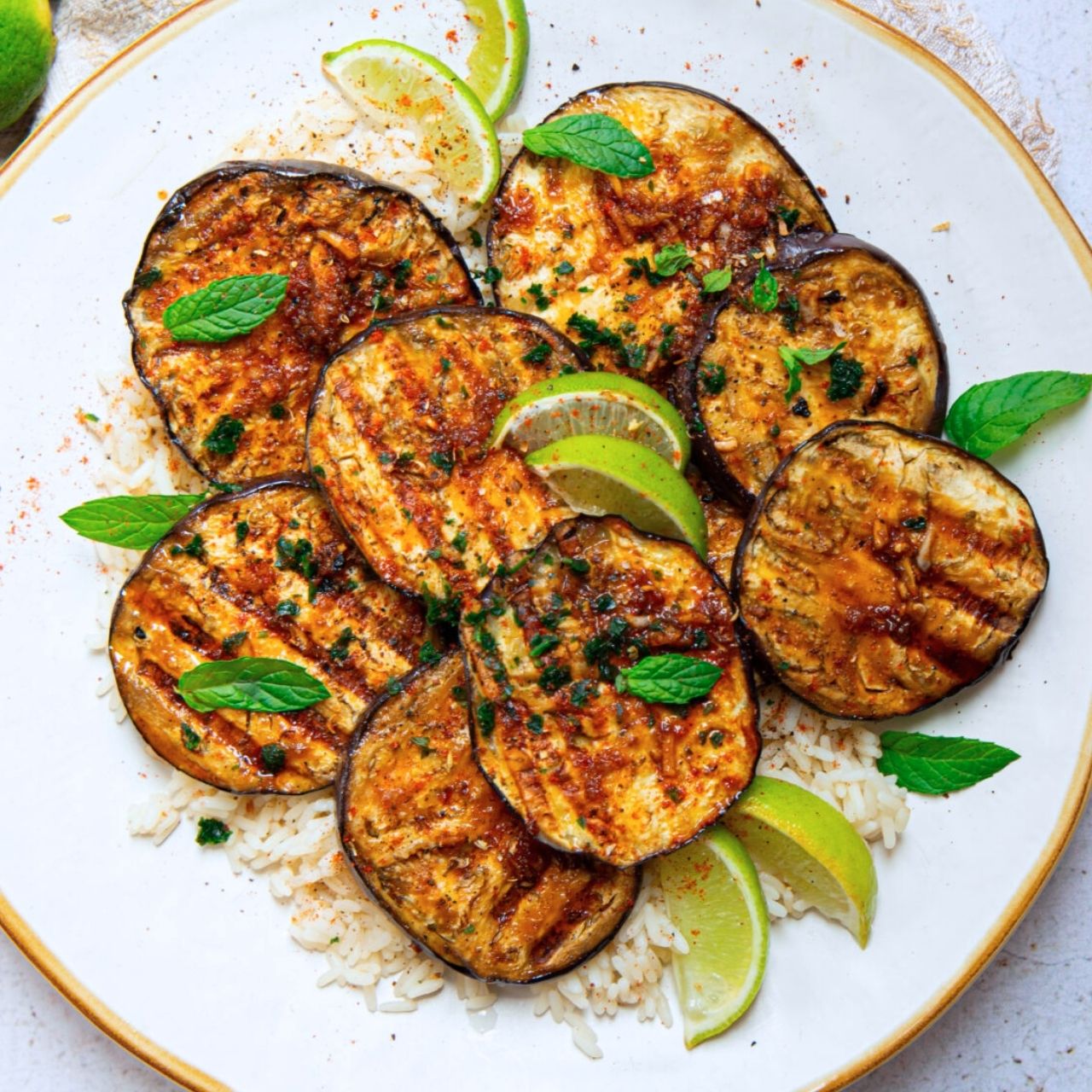 Aubergines marinées et grillées dans une assiette blanche