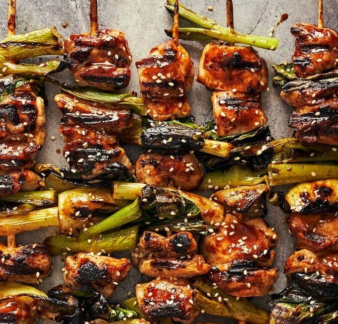brochettes d'agneau avec de la tomate et oignon rouge sur une assiette blanche