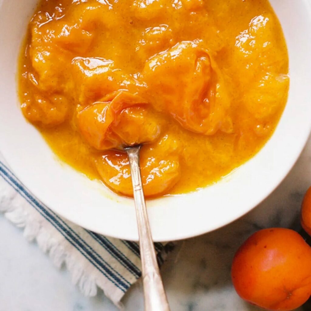 Compote d'abricot servie dans un bol blanc avec une cuillère