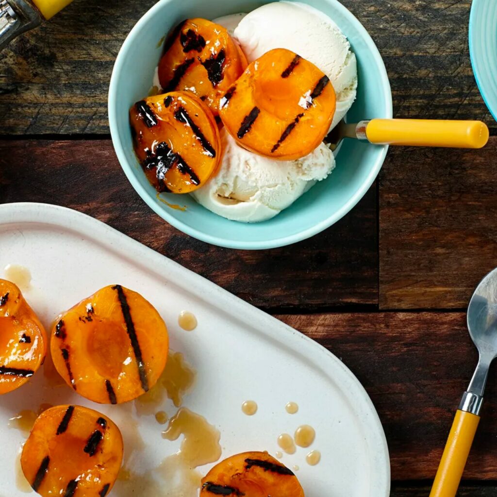 Dessert d'abricots grillés servi avec de la glace dans un bol bleu