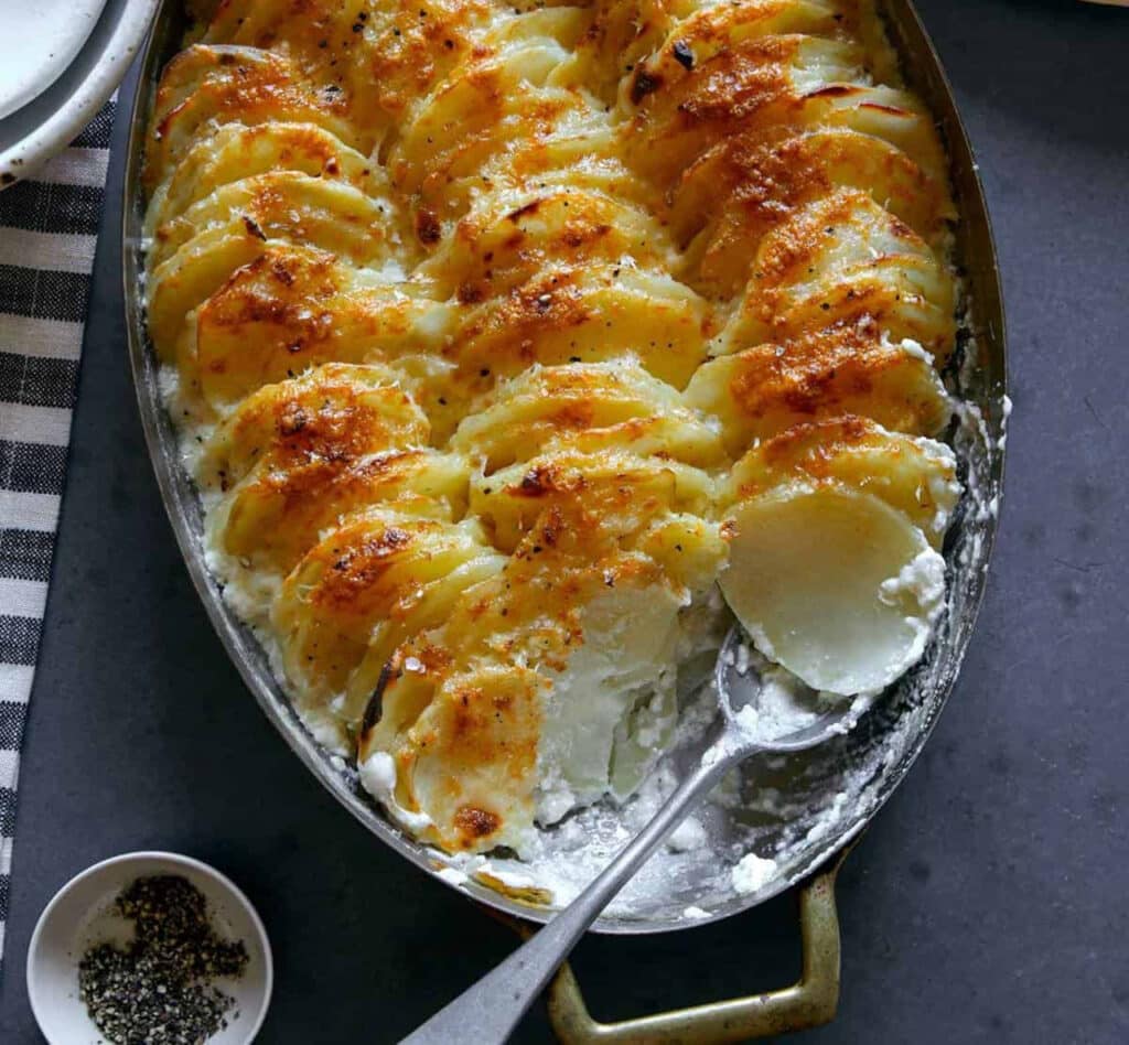 gratin de pommes de terre avec cuillère dans un plat au four