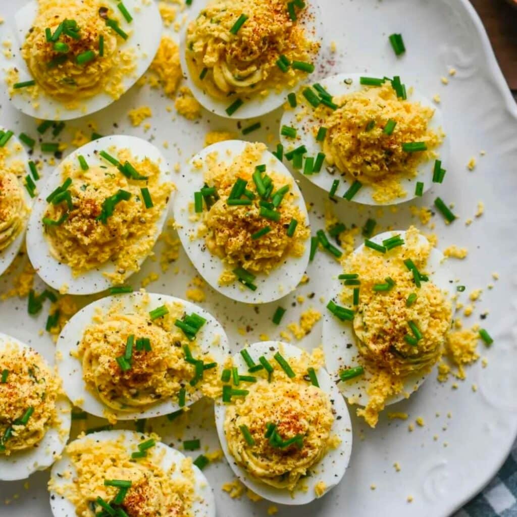 Oeufs Mimosa sur une assiette blanche avec des herbes