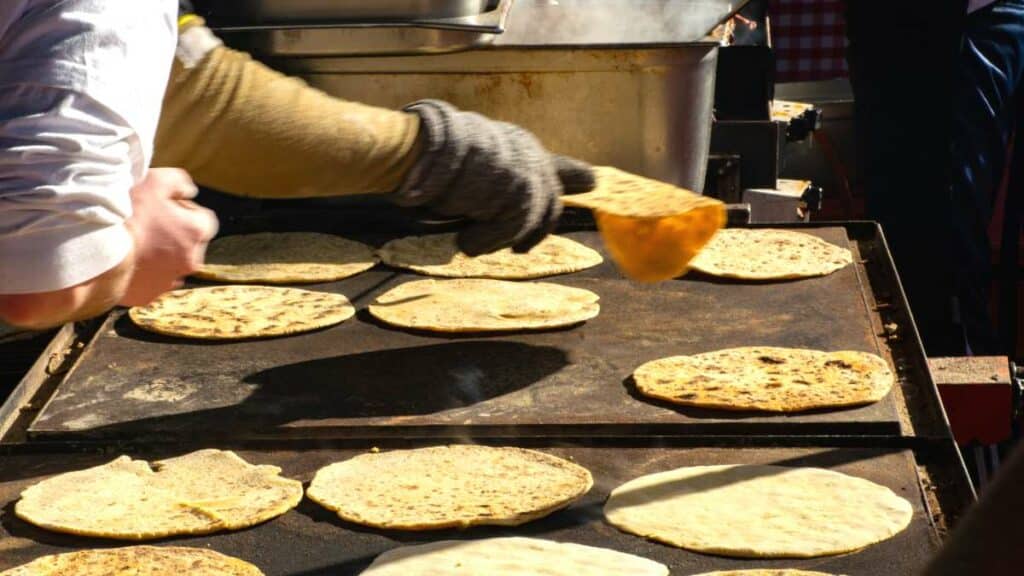 Plusieurs taloak basques en cours de cuisson sur de grandes plaques