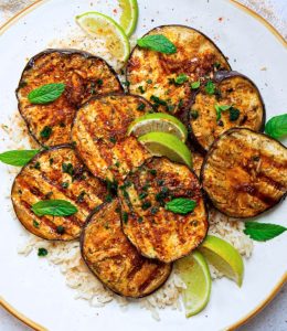 Aubergines marinées et grillées dans une assiette blanche