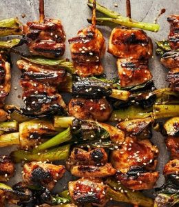 brochettes d'agneau avec de la tomate et oignon rouge sur une assiette blanche