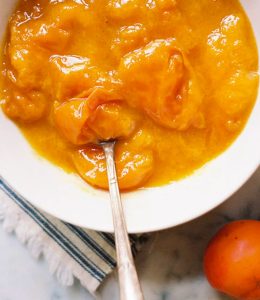 Compote d'abricot servie dans un bol blanc avec une cuillère
