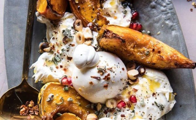 Courges et burrata cuits au four avec du buerre et du miel, servi dans un plat gris avec de la grenade