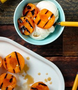 Dessert d'abricots grillés servi avec de la glace dans un bol bleu