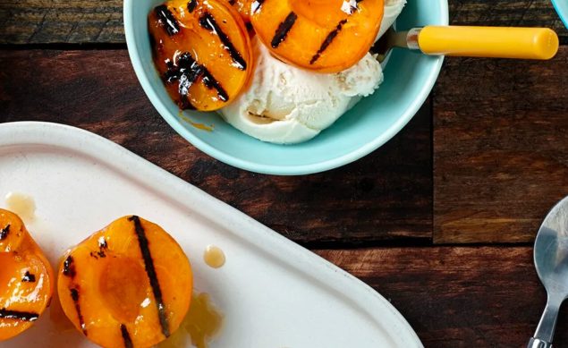 Dessert d'abricots grillés servi avec de la glace dans un bol bleu
