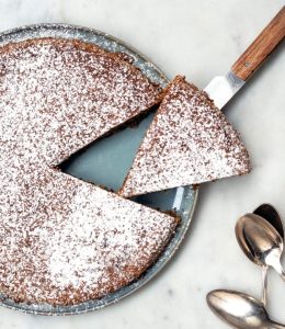 gâteau à la noisette avec du sucre glace par dessus et des cuillères