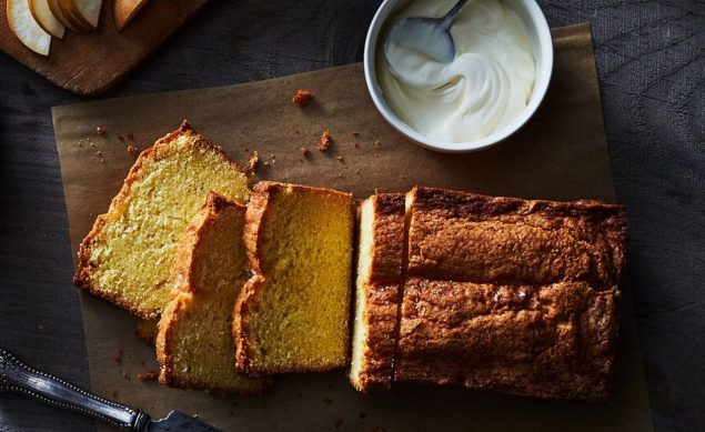 cake découpé sur une planche en bois avec un pot de yaourt à côté