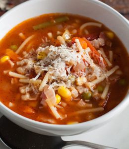soupe de légumes avec un bouillon et des pâtes dans un bol blanc