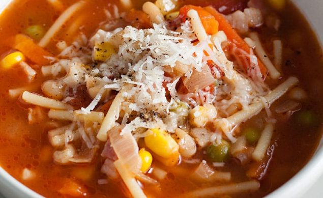 soupe de légumes avec un bouillon et des pâtes dans un bol blanc