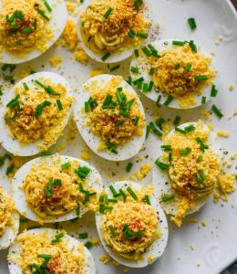 Oeufs Mimosa sur une assiette blanche avec des herbes