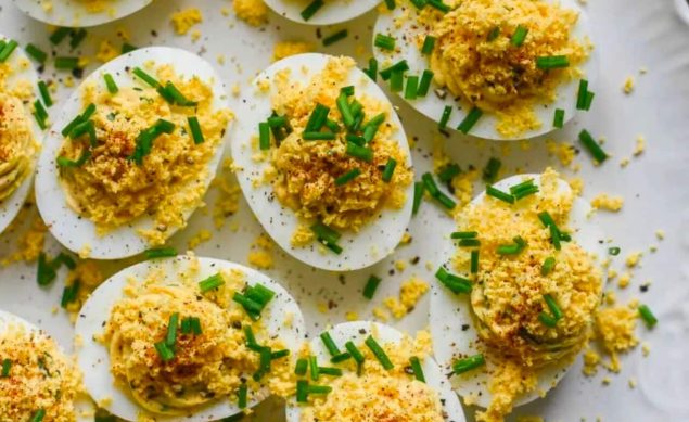 Oeufs Mimosa sur une assiette blanche avec des herbes