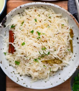 riz indien au cumin servi avec de la coriandre et autres épices dans un bol