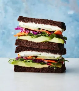 Sandwich veggie pique-nique avec de l'avocat, concombre, boursin et carotte et chou rouge.
