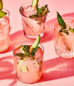 Sangria Rose, dans des verres avec des herbes comme basilic / menthe et des concombres