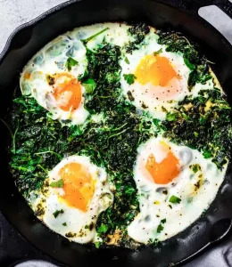 Des œufs avec des légumes cuits ensemble dans une poêle noire