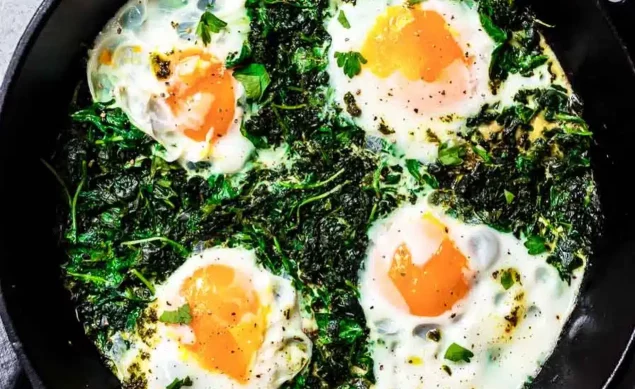 Des œufs avec des légumes cuits ensemble dans une poêle noire