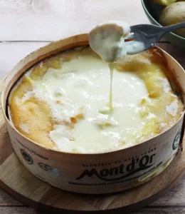 mont d'or aux saucisses avec une fourchette qui trempe du pain
