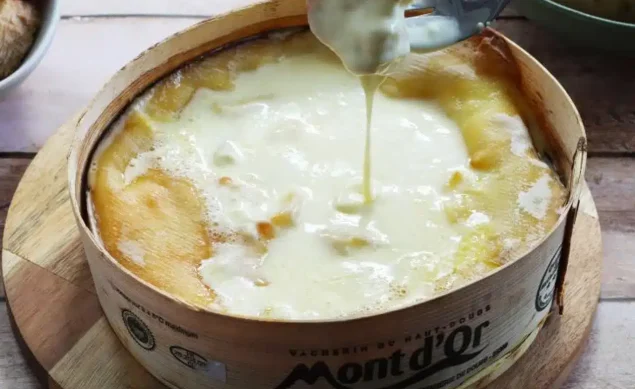 mont d'or aux saucisses avec une fourchette qui trempe du pain